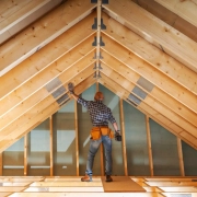 ouvrier regardant la charpente qu'il vient de construire