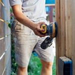 ouvrier installe un bardage en bois